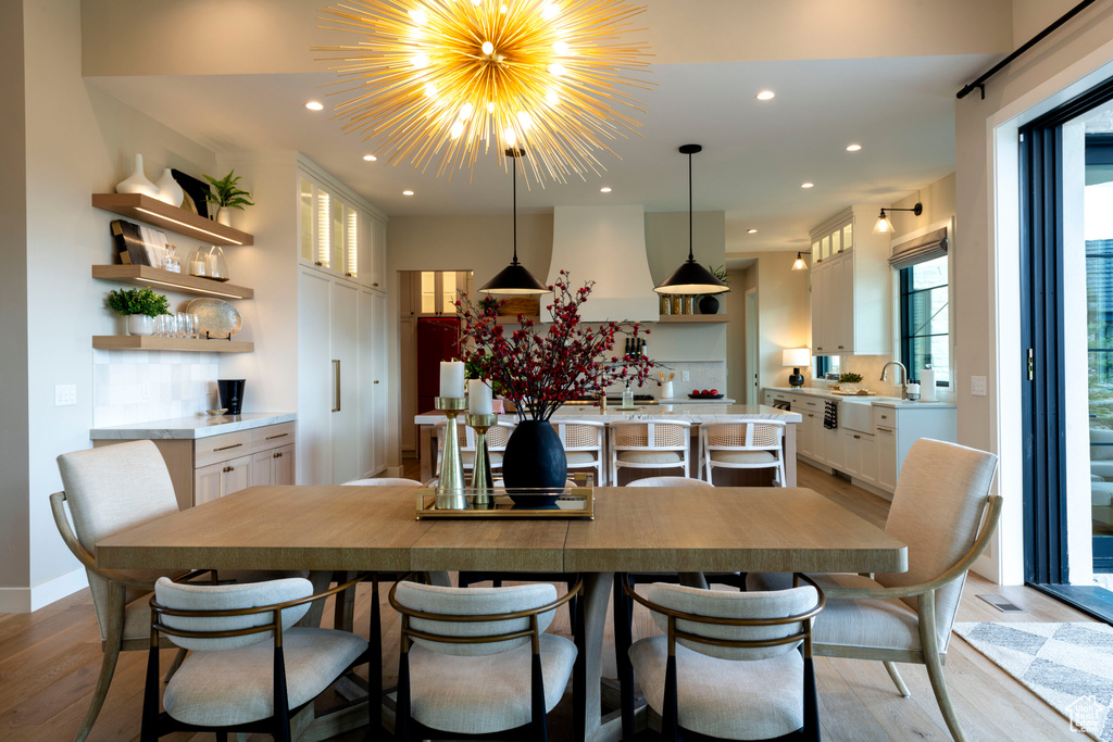Dining room featuring light wood finished floors, recessed lighting, and a chandelier