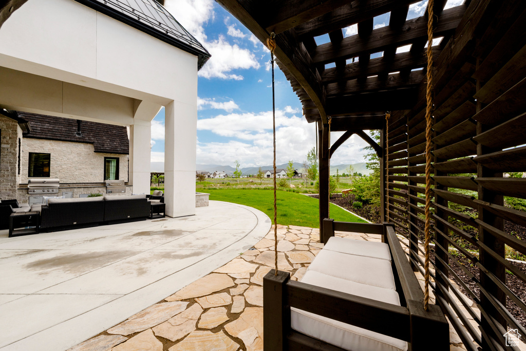 View of patio with an outdoor hangout area, a mountain view, and exterior kitchen