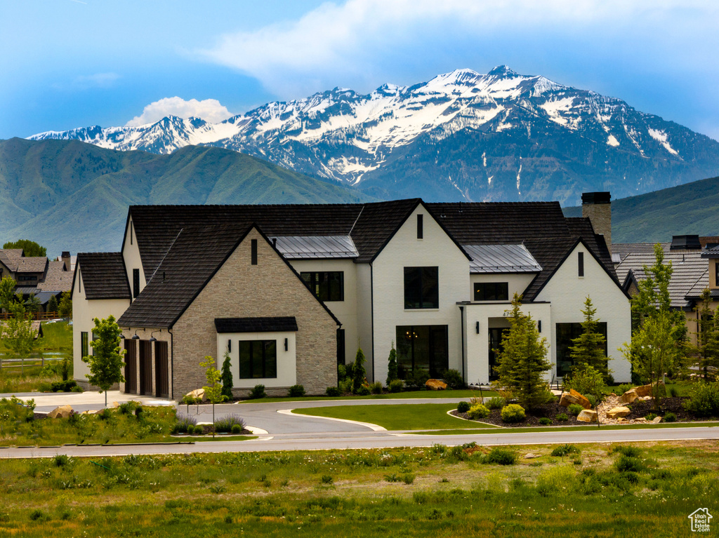 View of front of property with a mountain view, a chimney, a standing seam roof, and a metal roof