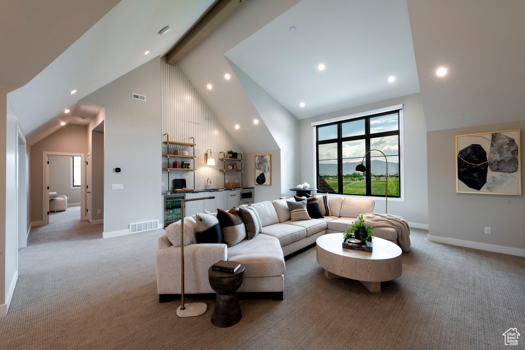 Living area featuring wine cooler, bar with sink, high vaulted ceiling, light carpet, and beamed ceiling