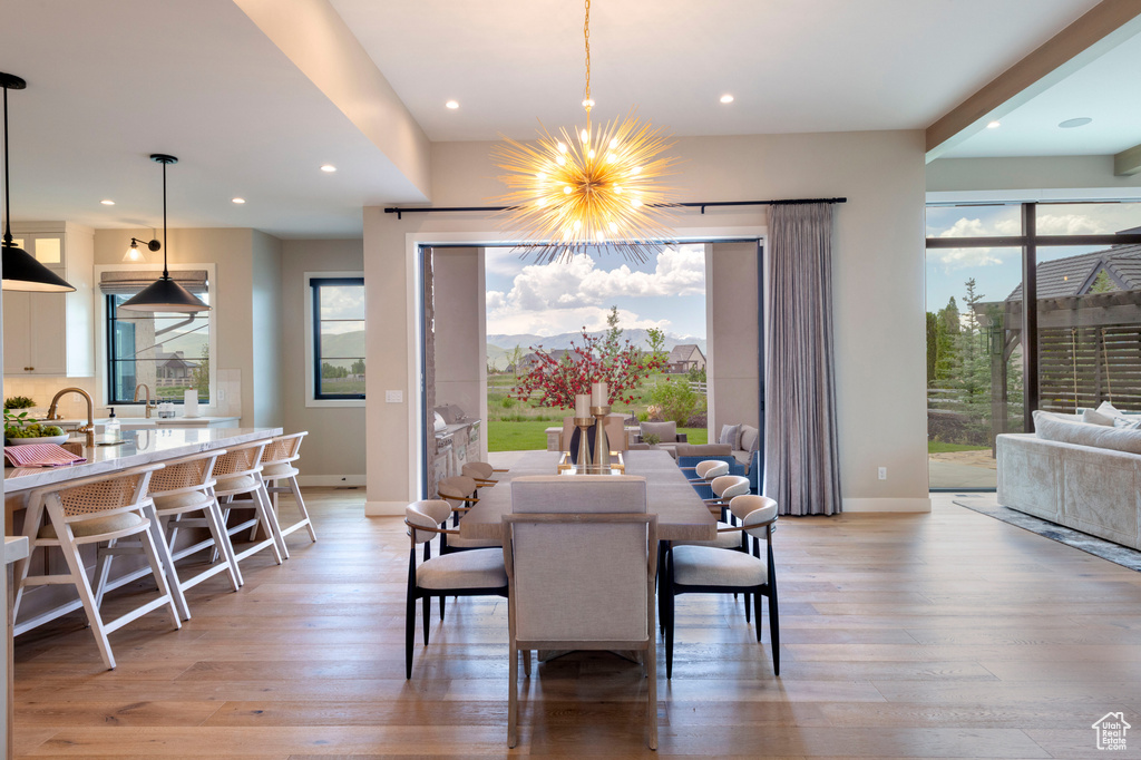 Dining area with light wood-style floors, a chandelier, and recessed lighting