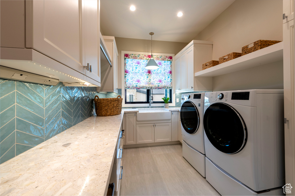 Laundry area with washing machine and clothes dryer, recessed lighting, and cabinet space