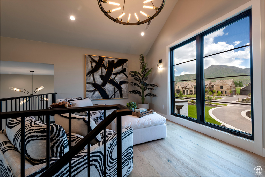Living area with a chandelier, wood finished floors, a mountain view, recessed lighting, and high vaulted ceiling