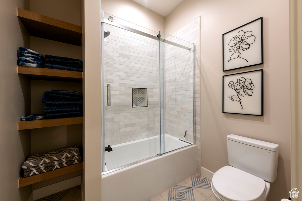 Full bath with enclosed tub / shower combo and tile patterned floors