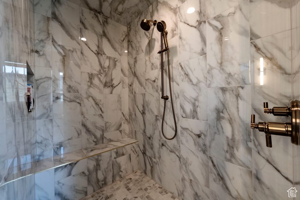 Full bath with a marble finish shower