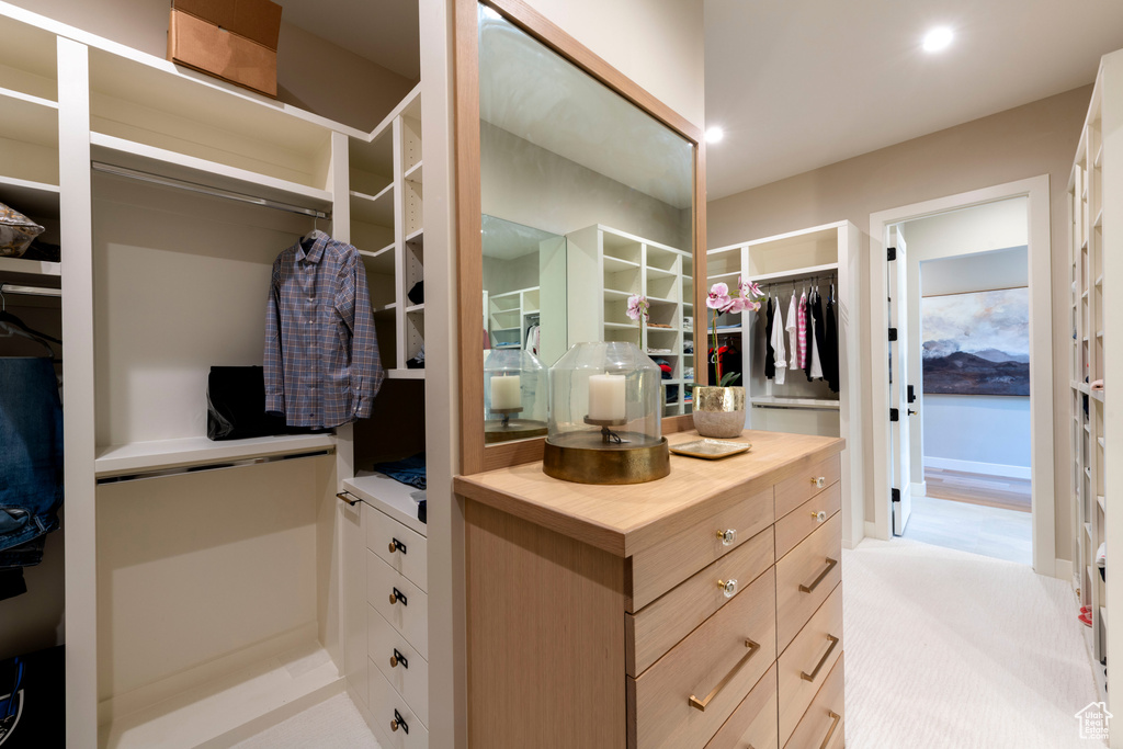 Walk in closet with light colored carpet