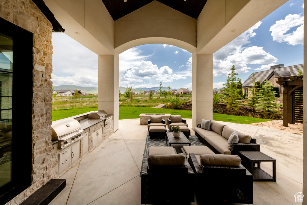 View of patio / terrace featuring exterior kitchen, an outdoor hangout area, and a mountain view