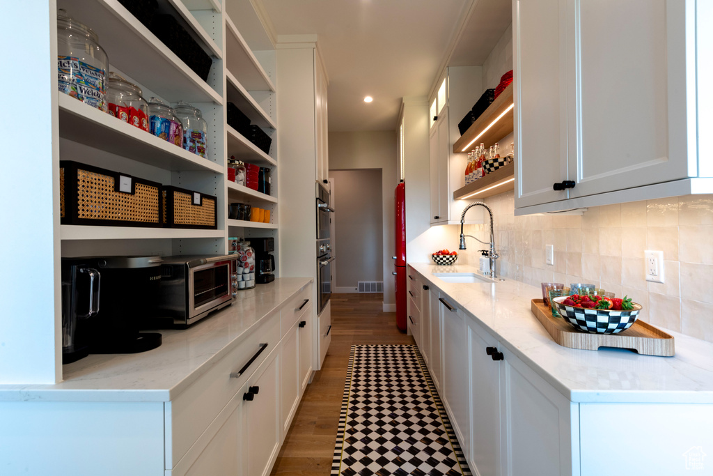 Kitchen with open shelves, decorative backsplash, white cabinetry, recessed lighting, and stainless steel double oven