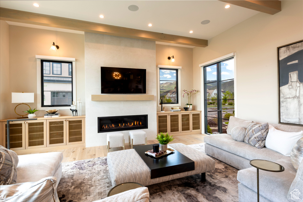 Living room featuring wood finished floors, a large fireplace, and recessed lighting