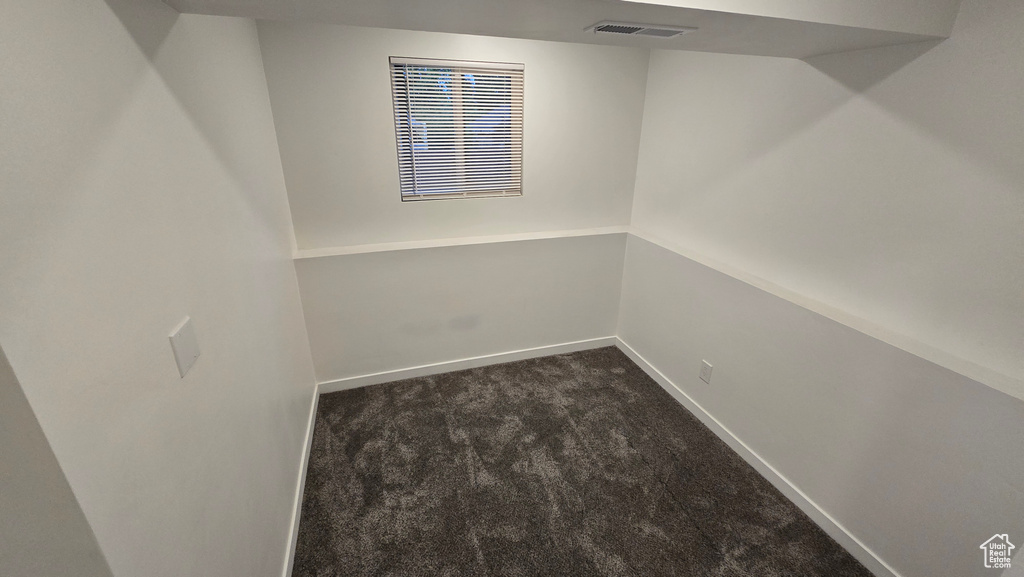 Finished basement featuring dark colored carpet and baseboards