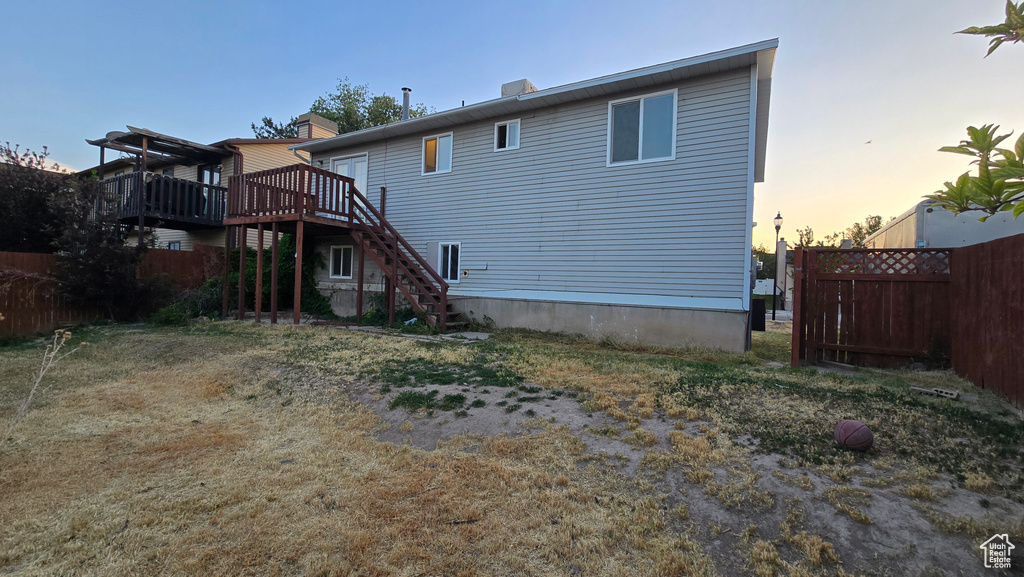 Rear view of house with stairs and a wooden deck