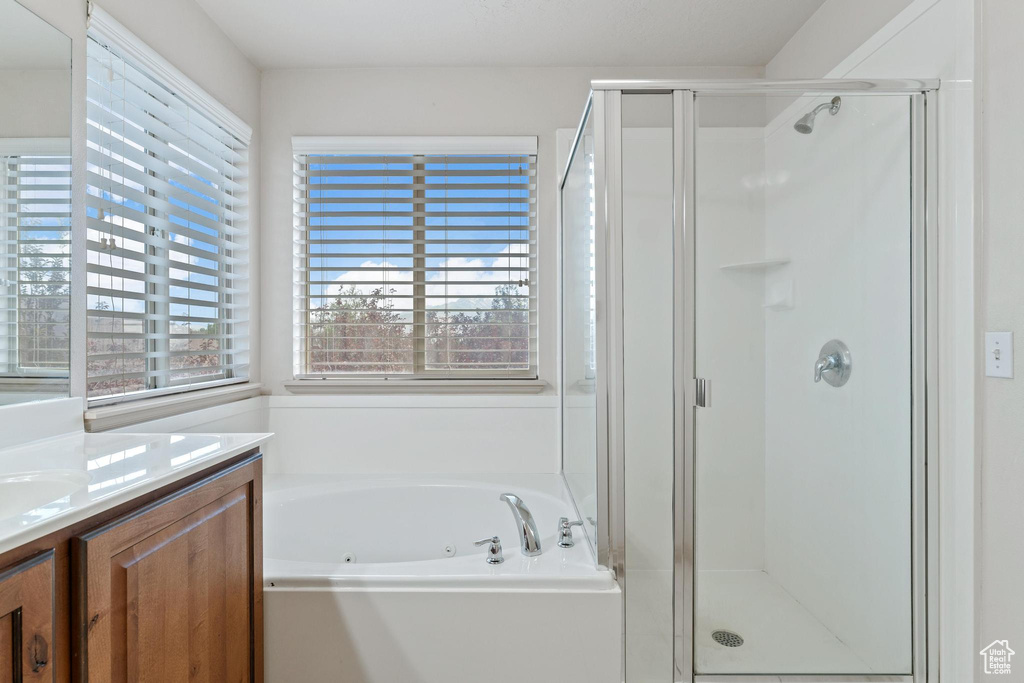 Full bath with a shower stall, vanity, and a tub with jets