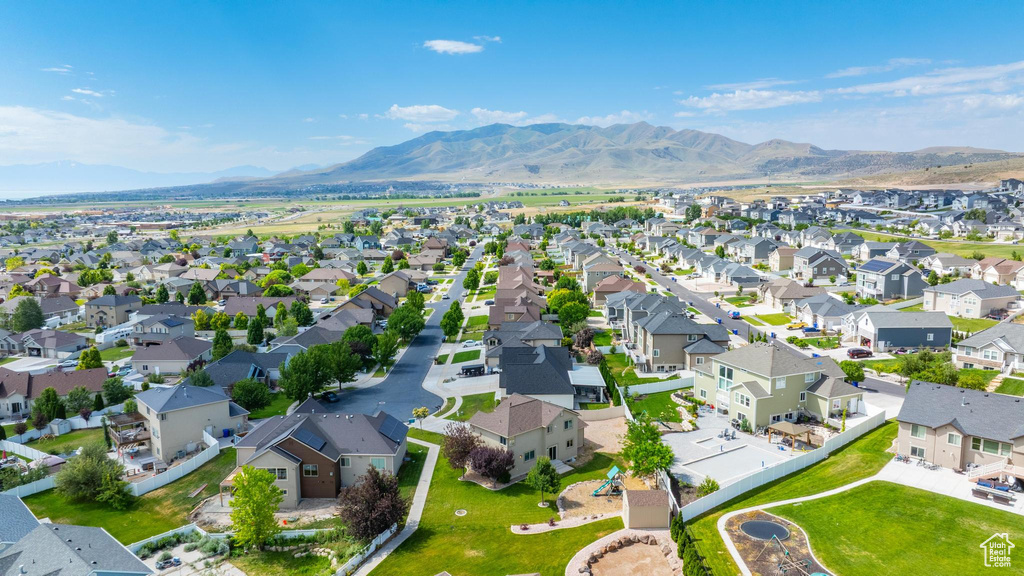 Aerial view of property and surrounding area featuring a mountainous background and nearby suburban area