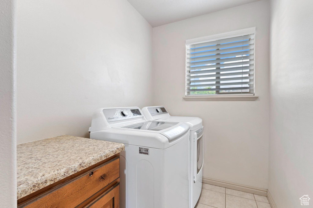 Laundry area featuring washing machine and dryer and light tile patterned floors