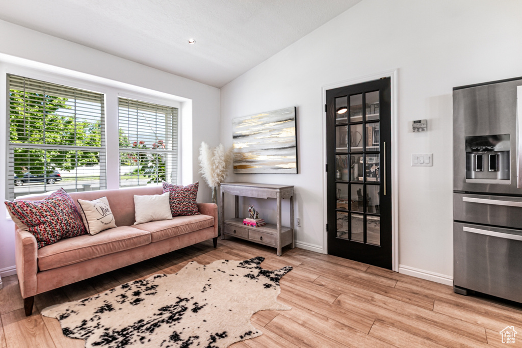 Living area with vaulted ceiling and light wood finished floors
