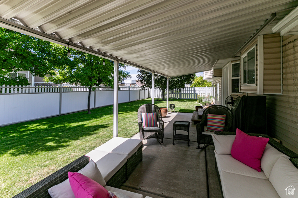 Fenced backyard with an outdoor living space and a patio area
