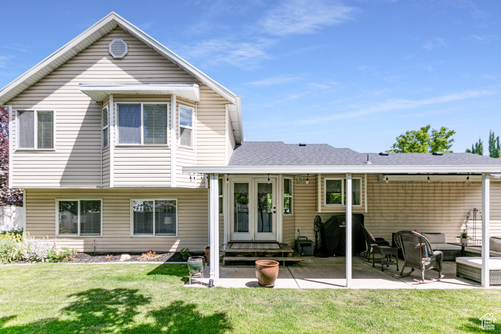 Rear view of property with a patio, outdoor lounge area, a yard, entry steps, and french doors