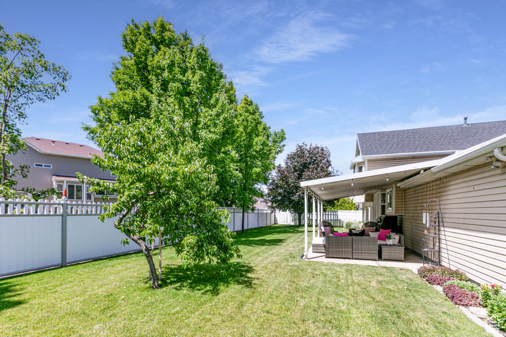Fenced backyard with outdoor lounge area and a patio
