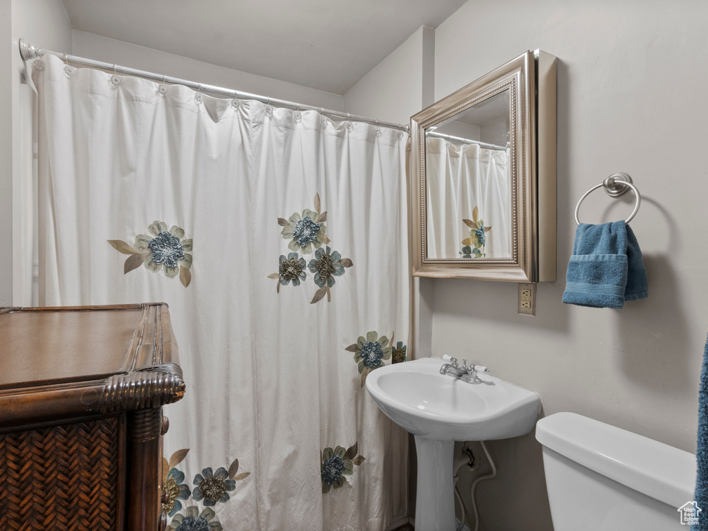 Full bathroom featuring toilet and curtained shower