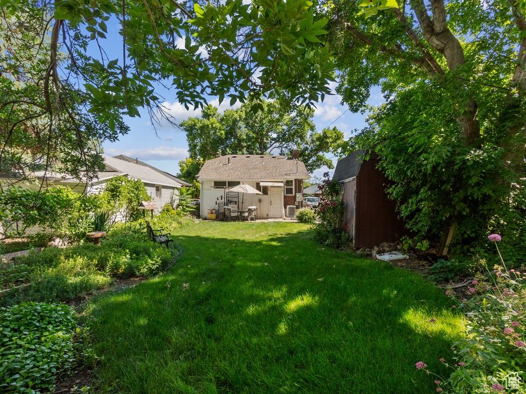 View of grassy yard featuring an outbuilding