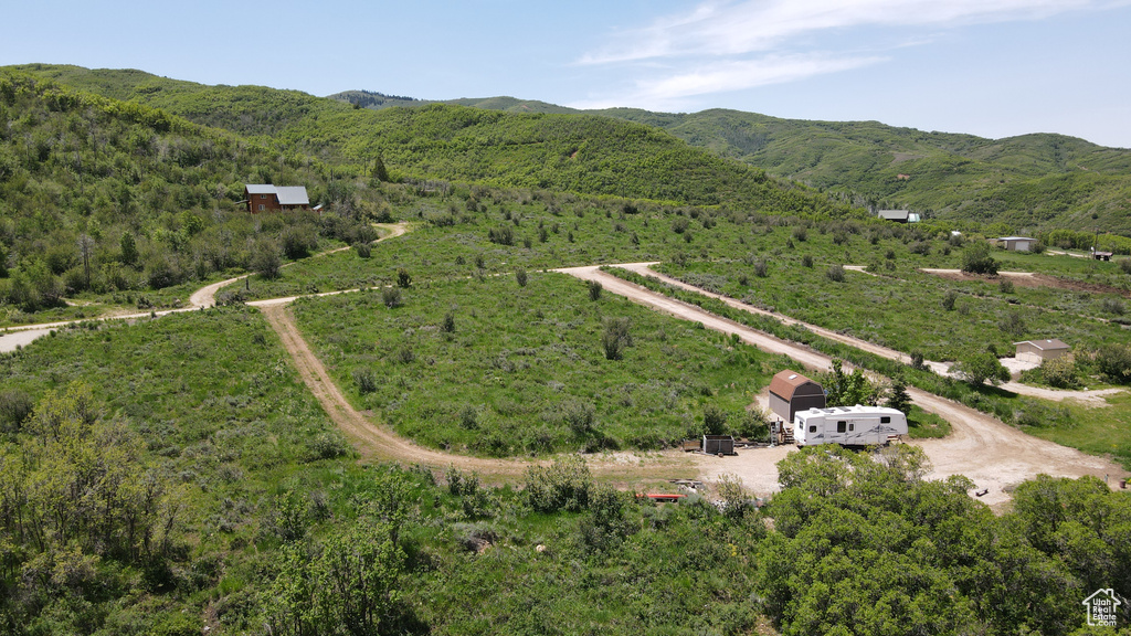 Overview of rural landscape featuring a mountain backdrop and a heavily wooded area