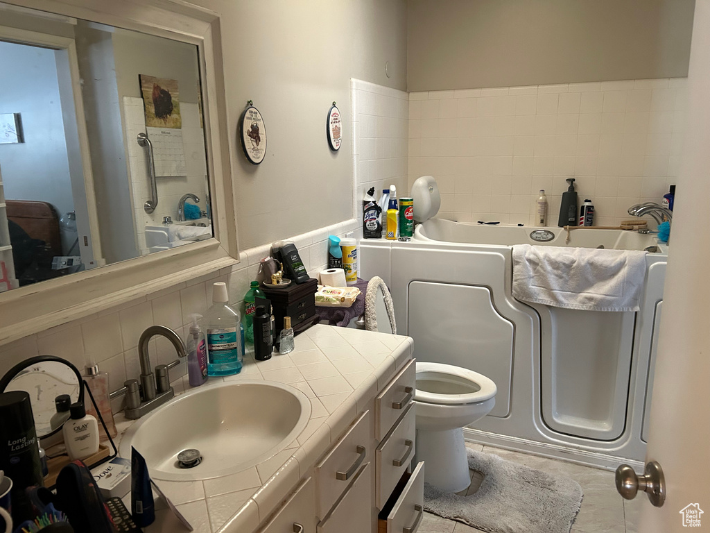 Full bathroom with a bath, vanity, toilet, and tasteful backsplash