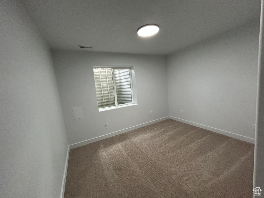 Carpeted empty room featuring baseboards
