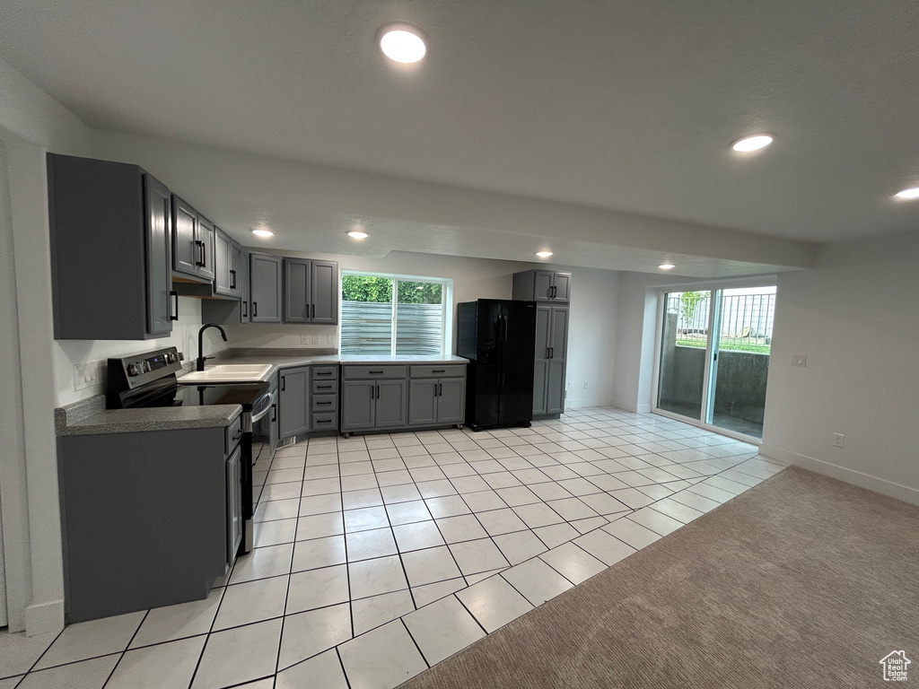 Kitchen with black appliances, recessed lighting, light tile patterned floors, gray cabinets, and light colored carpet