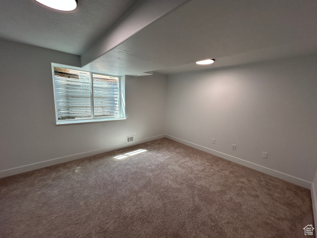 Carpeted spare room with baseboards