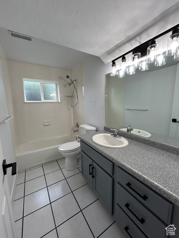 Full bathroom featuring vanity, shower / tub combination, tile patterned floors, and a textured ceiling