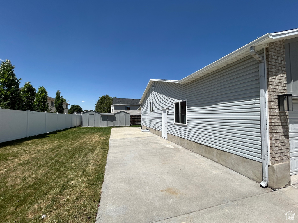 View of yard with a shed and a patio