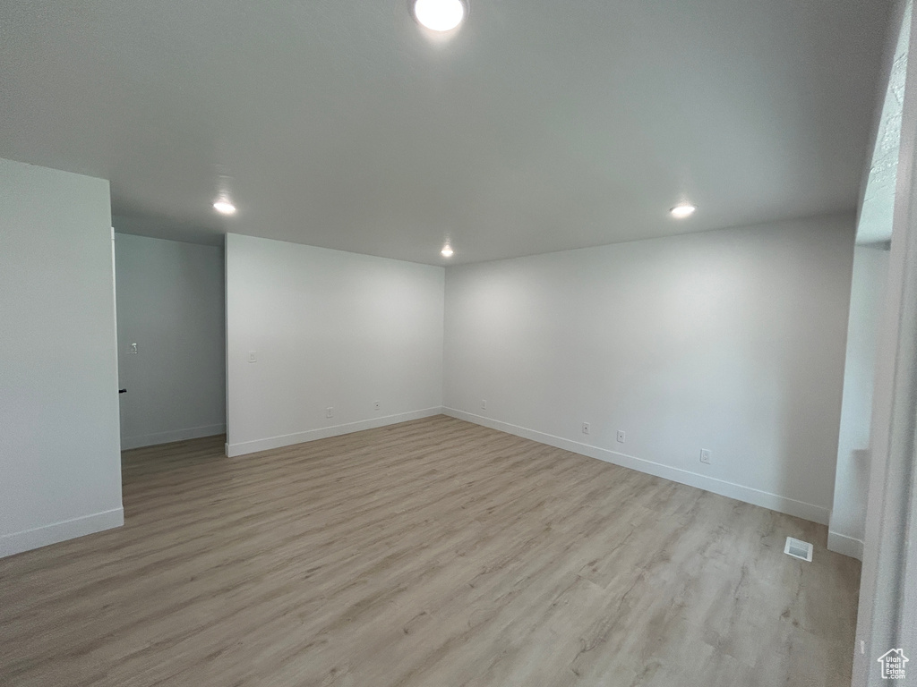 Empty room featuring light wood-style flooring and recessed lighting