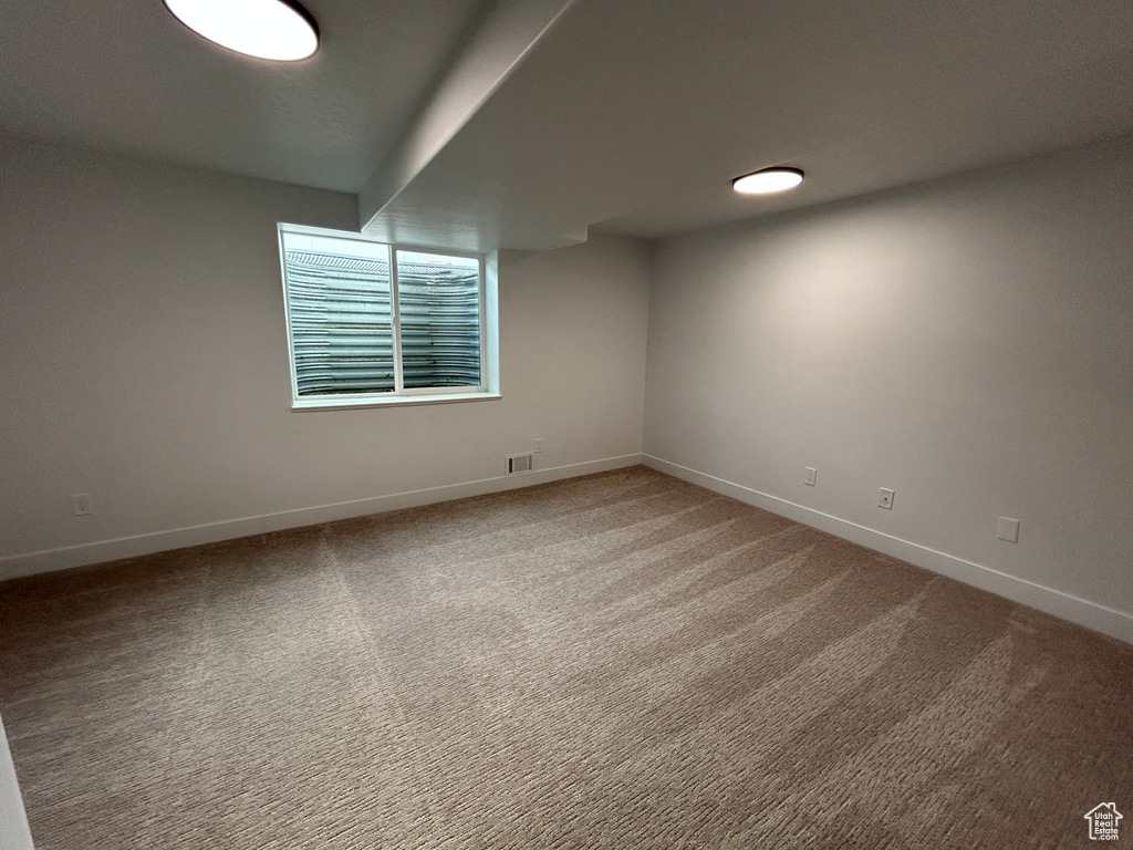 Spare room featuring baseboards and carpet