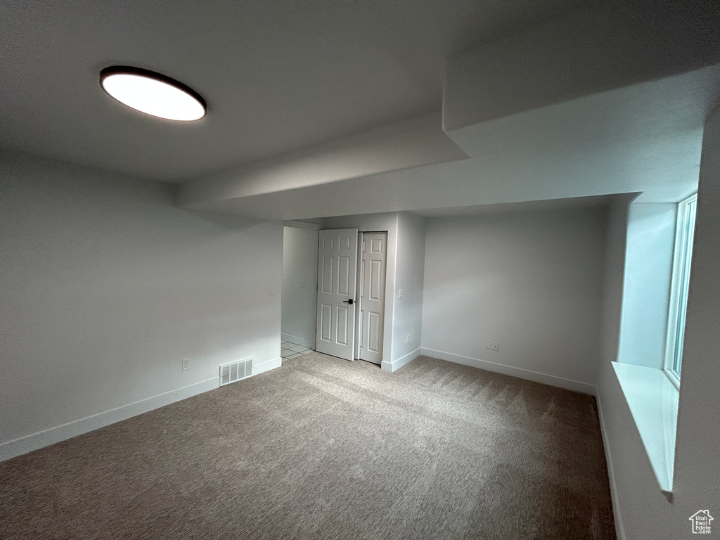 Finished below grade area featuring light carpet and baseboards
