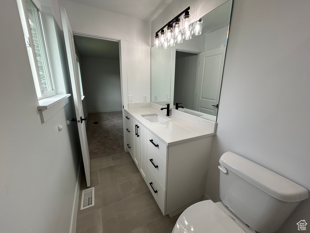 Half bathroom featuring vanity and tile patterned floors