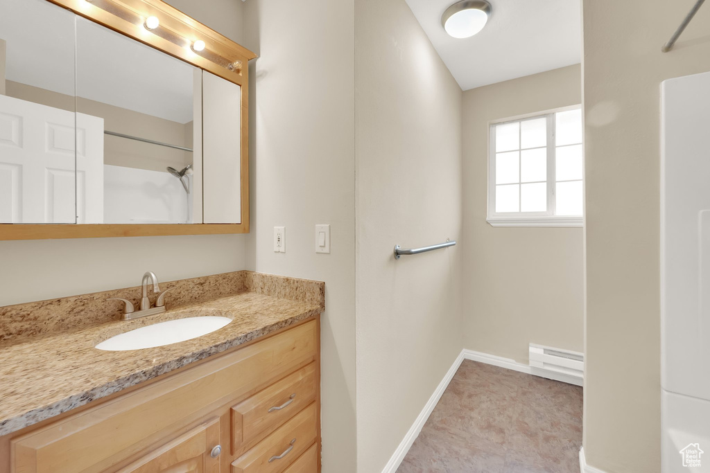 Bathroom with vanity, a baseboard radiator, and a shower