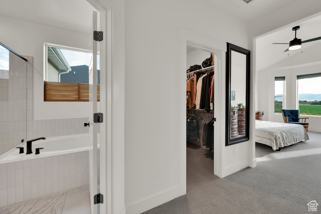 Bathroom featuring a garden tub, a ceiling fan, ensuite bathroom, a walk in closet, and tiled shower