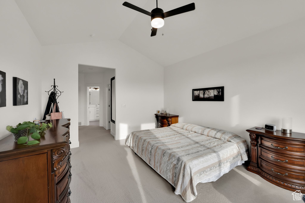 Bedroom featuring light colored carpet, vaulted ceiling, and a ceiling fan