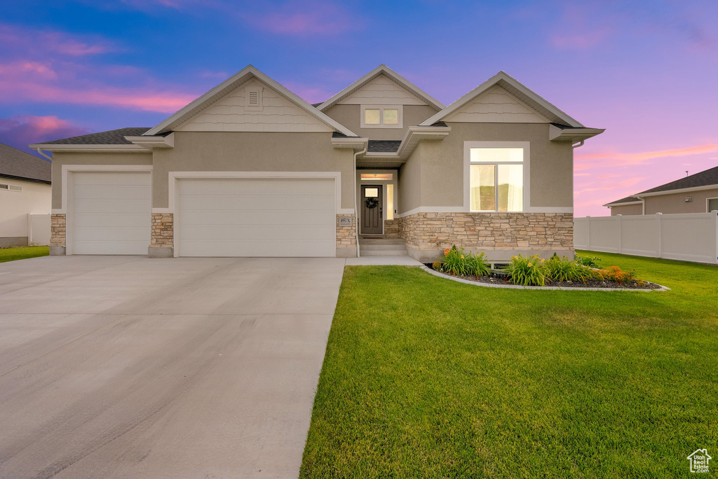 View of front of property with stone siding, stucco siding, a garage, and driveway