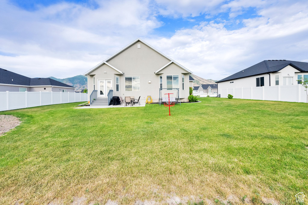 Back of house featuring entry steps, a fenced backyard, a patio area, and stucco siding