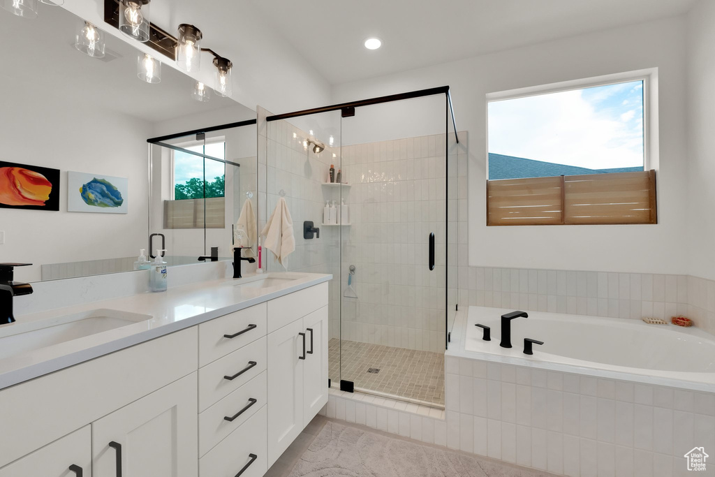 Full bathroom with a bath, double vanity, a shower stall, and recessed lighting
