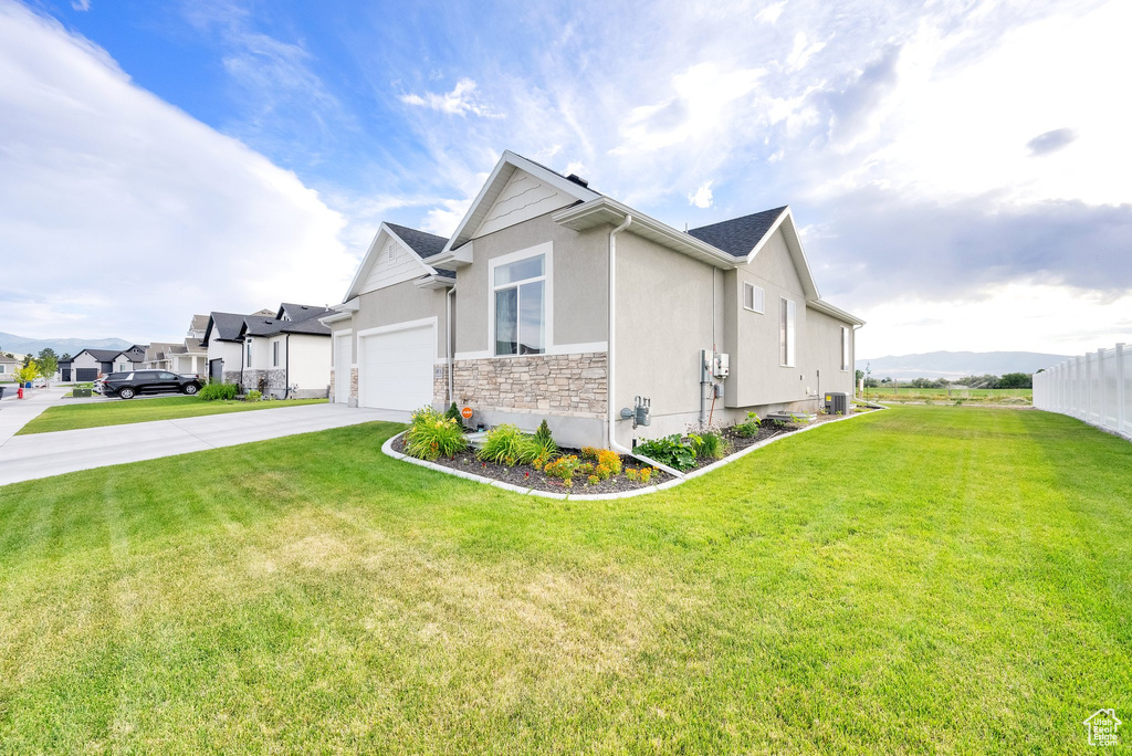 View of property exterior with stucco siding, concrete driveway, stone siding, and an attached garage