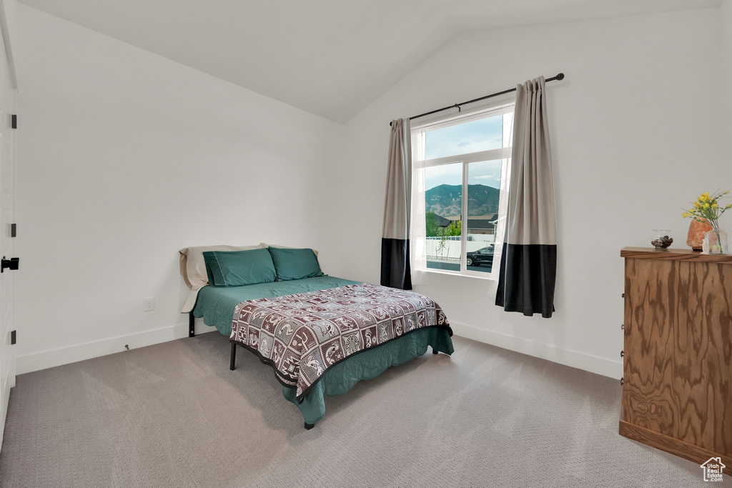 Bedroom with vaulted ceiling and carpet floors