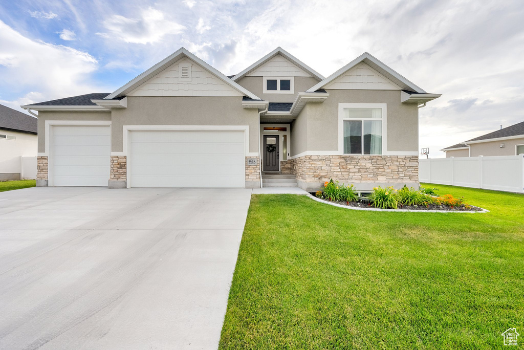Craftsman inspired home featuring stone siding, stucco siding, an attached garage, and driveway