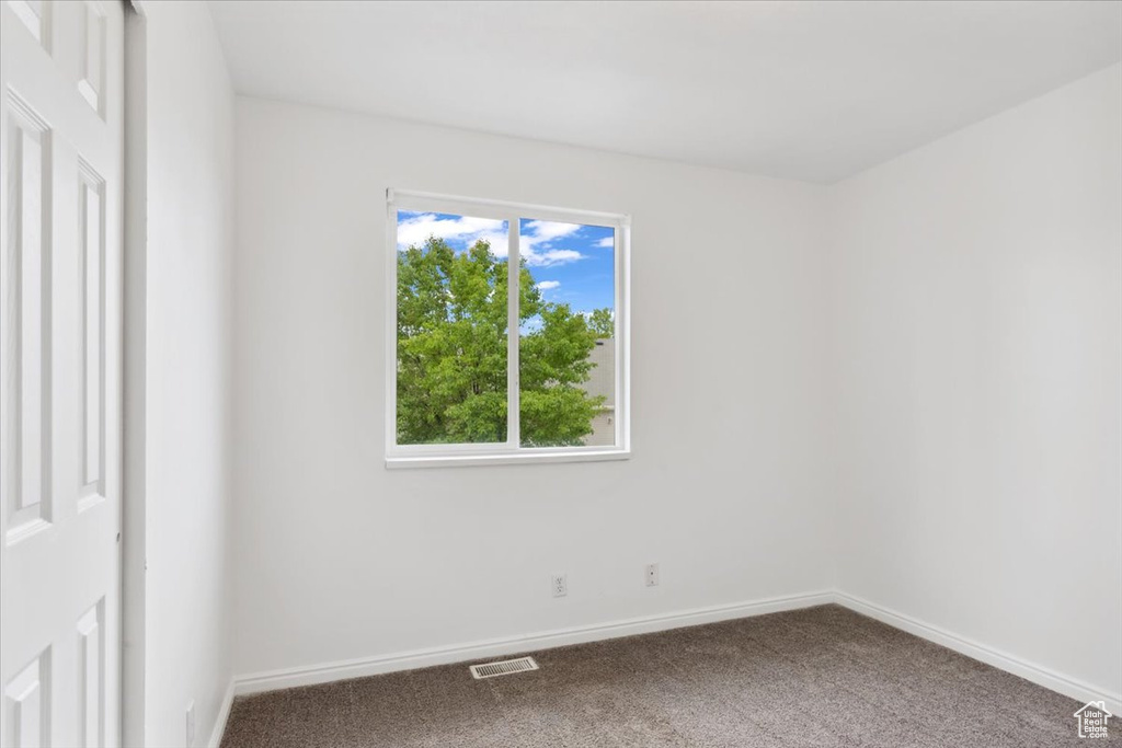 Empty room with carpet and baseboards