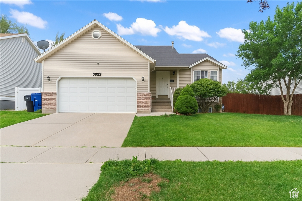 View of front facade with brick siding, concrete driveway, and a garage