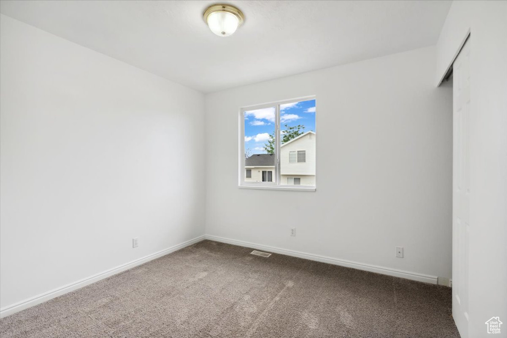 Carpeted empty room with baseboards