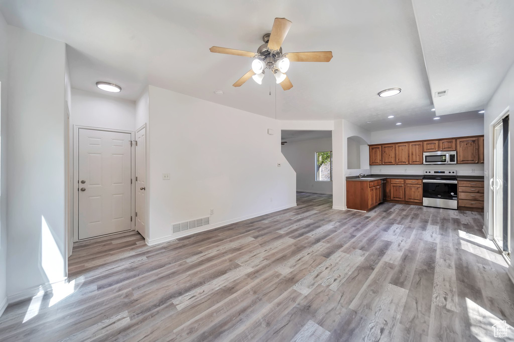 Unfurnished living room with light wood finished floors, ceiling fan, and recessed lighting