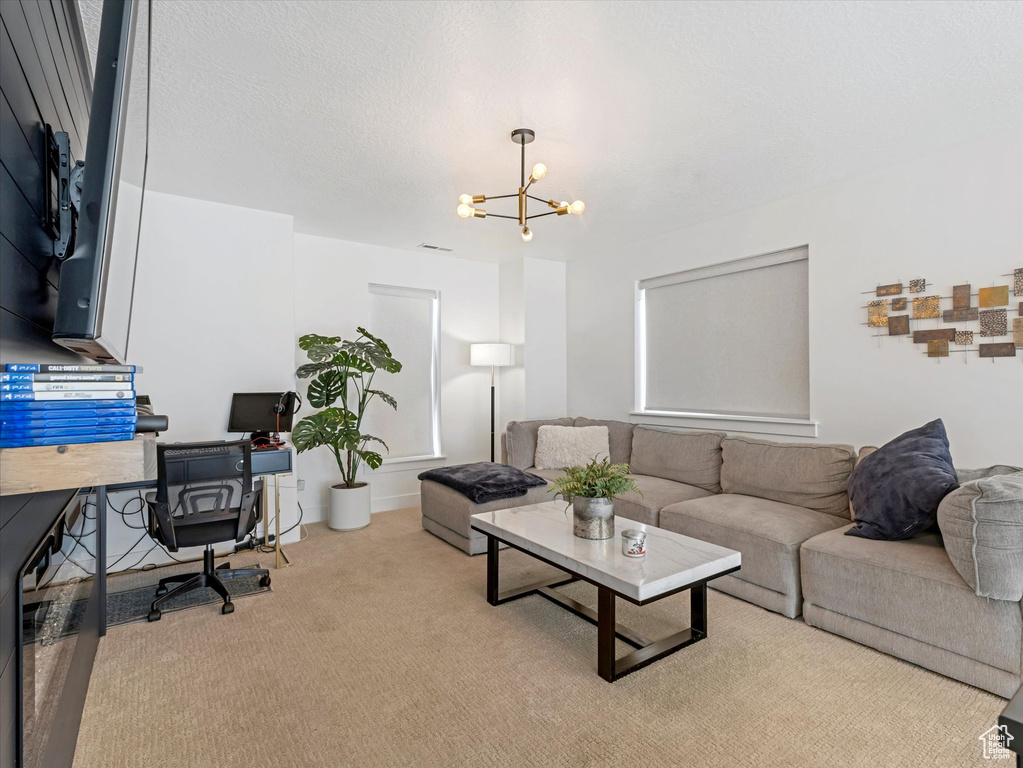 Living room featuring a chandelier, an office area, and carpet flooring