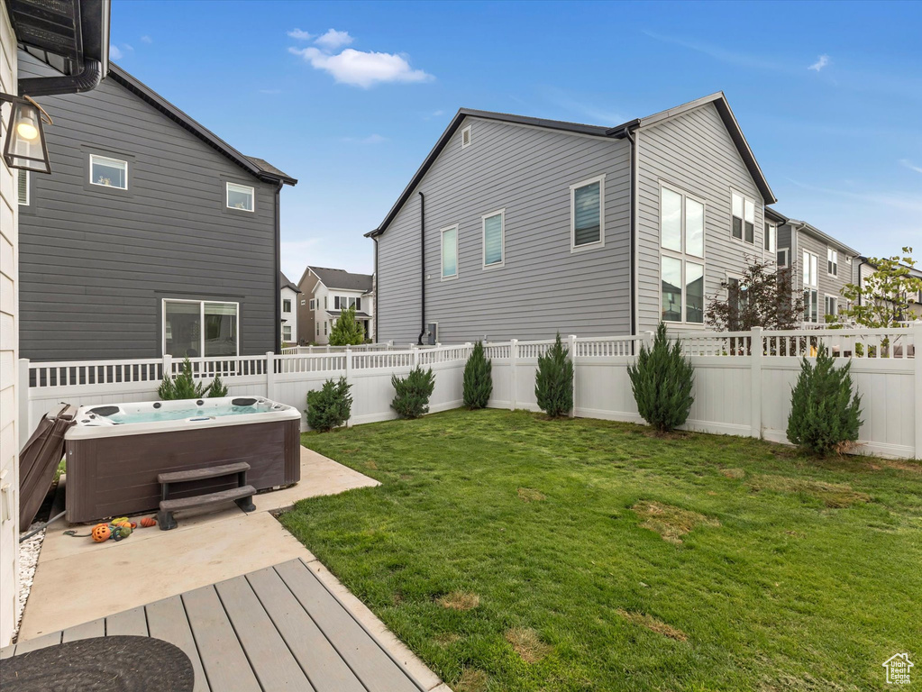 Fenced backyard featuring a hot tub and a residential view